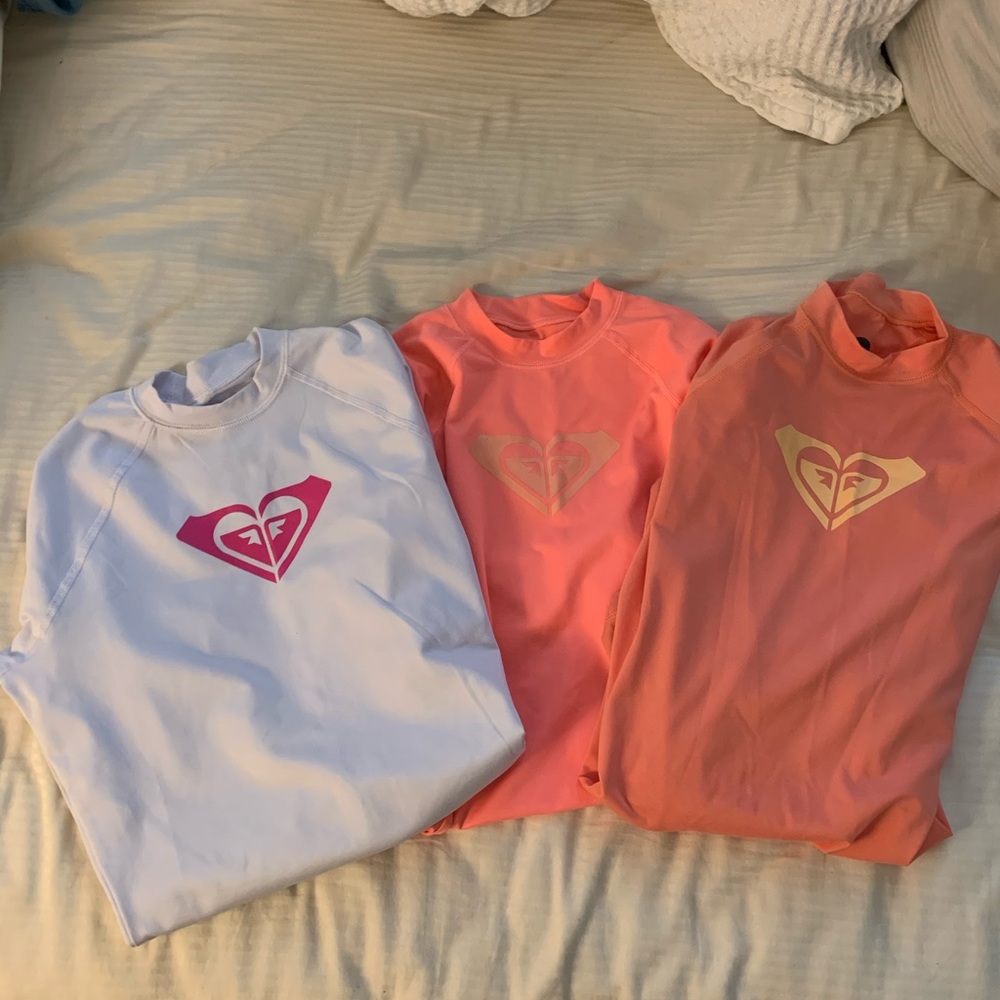 Three Roxy rash guards
